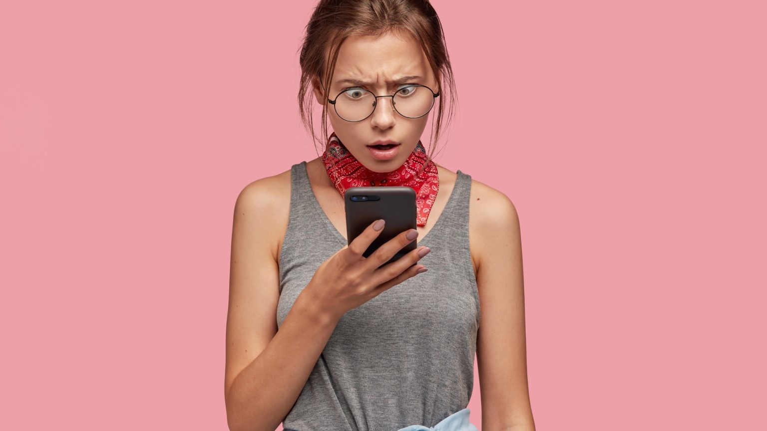 Gros plan d'un téléphone mobile affichant un appel entrant d'un numéro inconnu, symbole d'alerte en rouge sur l'écran